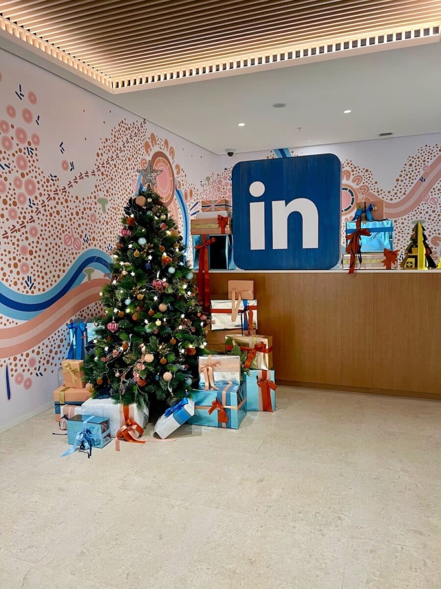 Beautifully styled corporate Christmas tree with presents and decorations at office reception area.