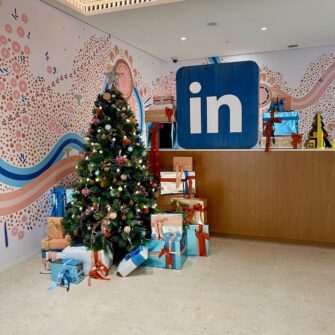 Beautifully styled corporate Christmas tree with presents and decorations at office reception area.